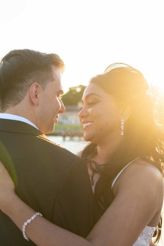 Bride and groom embracing at golden hour on Tampa Bay